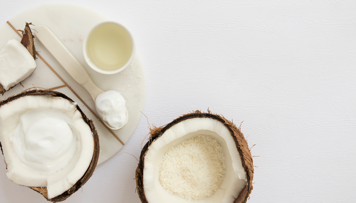 Coco sobre a mesa, em suas variações ralado, pastoso e o óleo de coco.